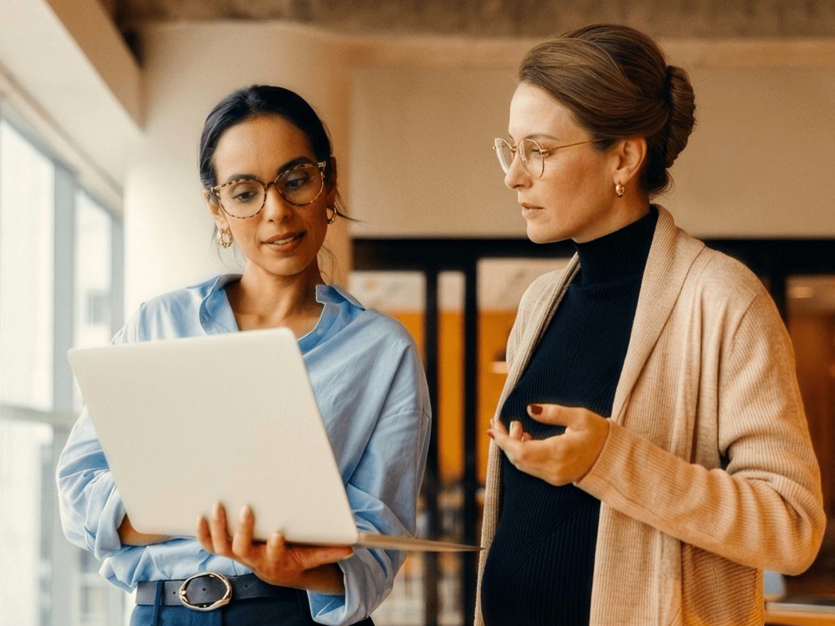 Two colleagues discussing work over a laptop