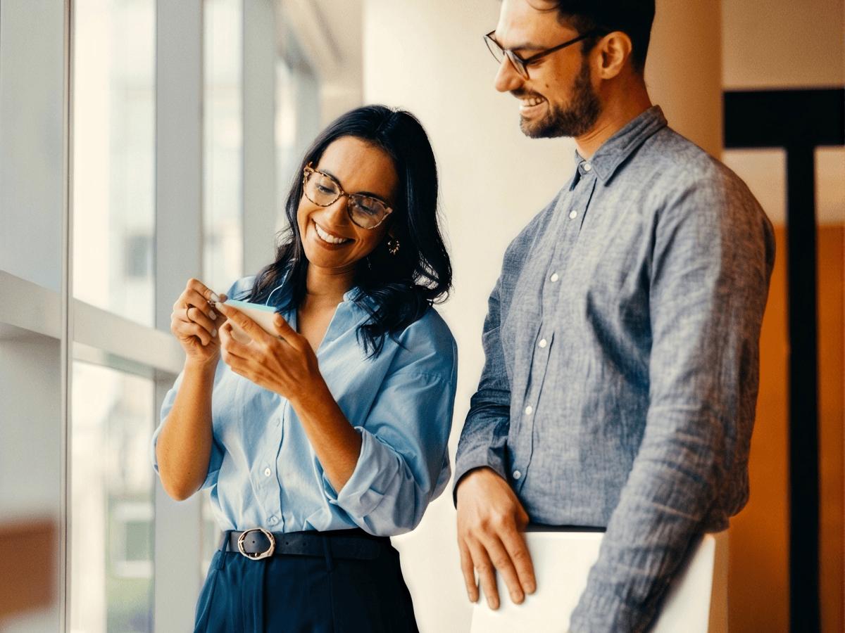 Two colleagues chatting in a bright office