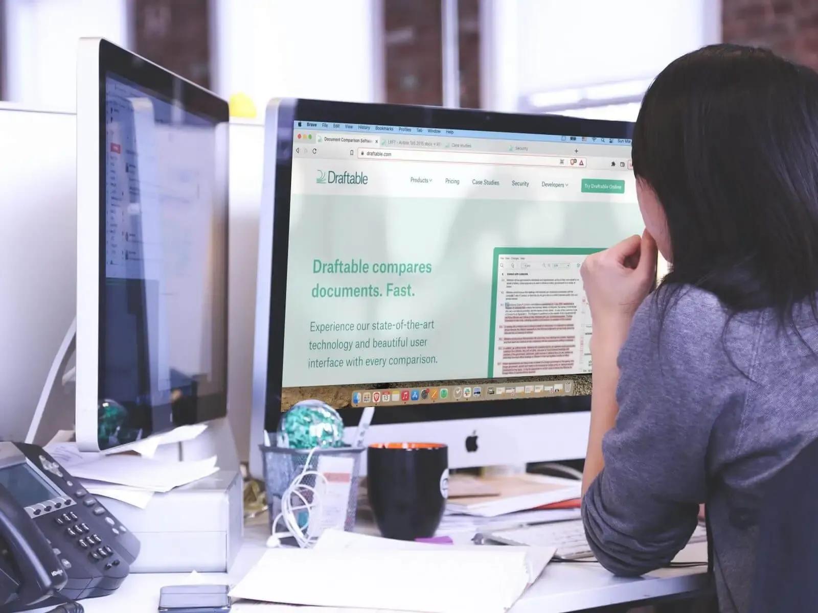 Person reviewing a document comparison on a computer monitor