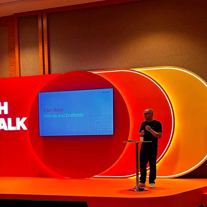 Speaker presenting on stage at a conference